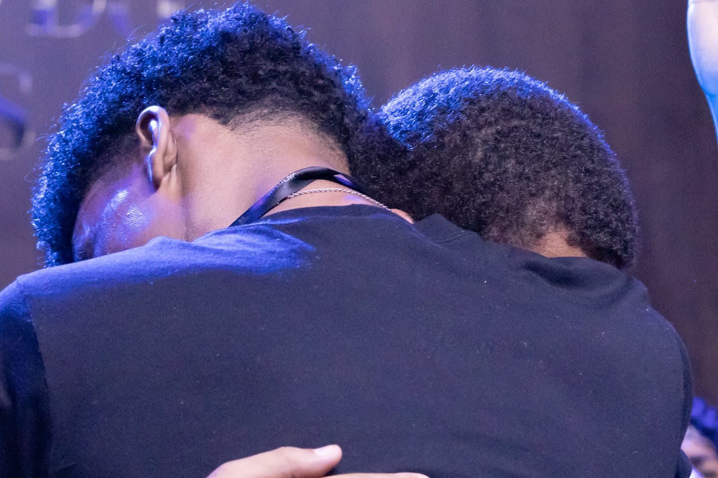 Foto de dois jovens se abraçando em uma igreja